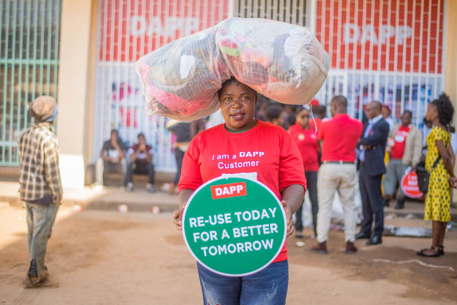 An ADPP Malawi customer buying bales of second-hand clothes 